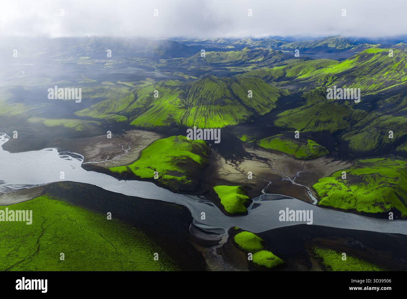 Aerial glacial river through mossy volcanic hills near Landmannalaugar Stock Photo