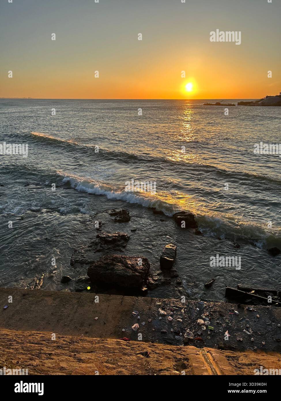 Scenic sun rise  over the Indian Ocean with gentle waves and a glowing horizon at the beach - Smartphone Captured Stock Image