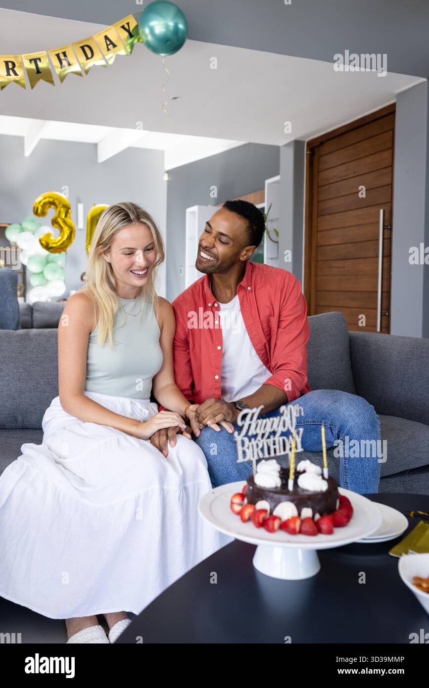 Couple celebrating birthday at home with cake and decorations, smiling  happily. Celebration, party, happiness, festivities, togetherness,  lifestyle || Model released Stock Photo - Alamy