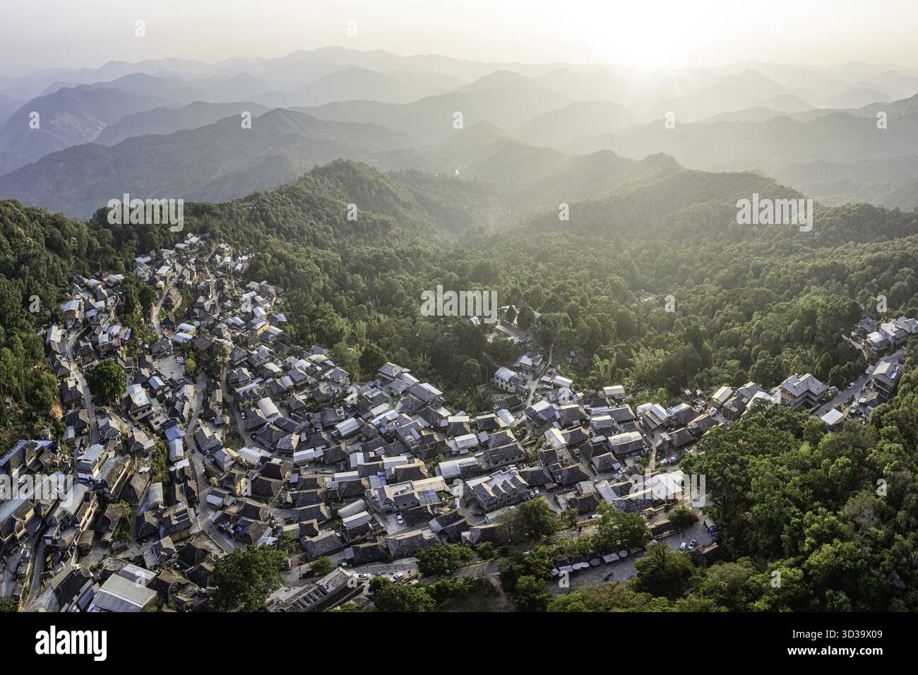 Aerial view of a village nestled in lush green hills, with houses ...