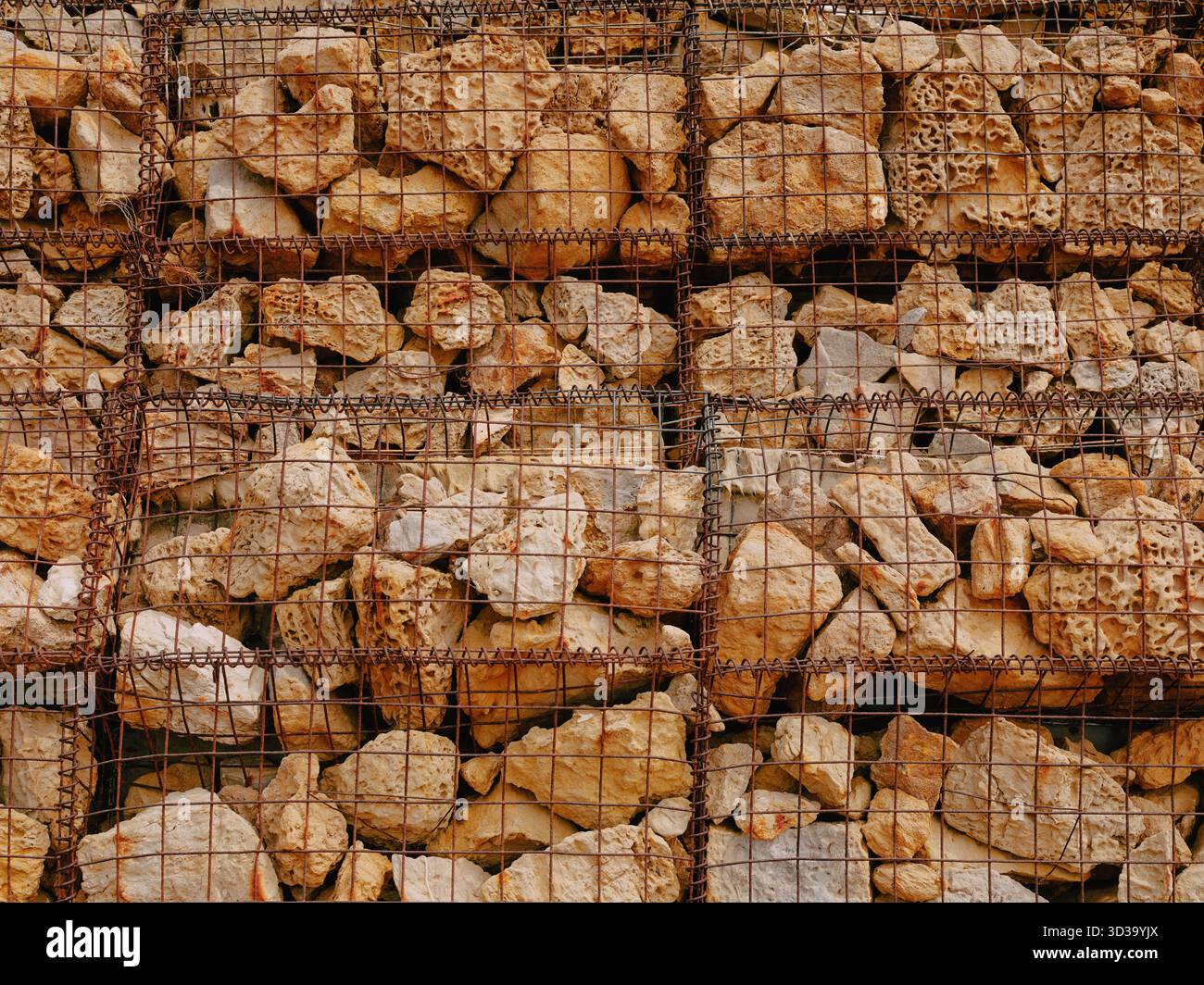 Gabions wire mesh cages of rocks used as sea defence to reduce coastal erosion - barrier manmade Stock Photo