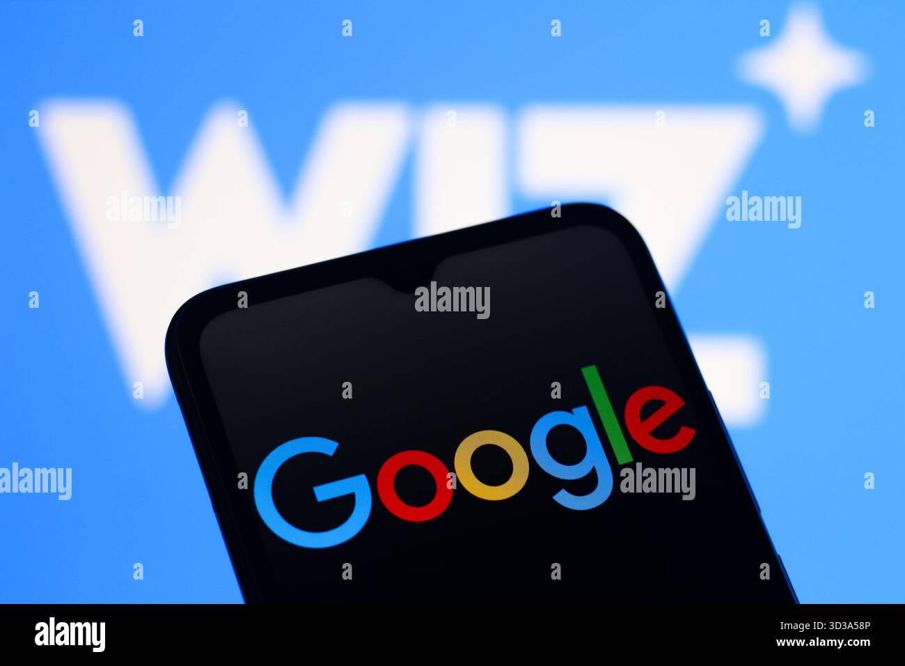 In this photo illustration, the Google logo is seen displayed on a smartphone screen and the Wiz logo in the background Stock Photo