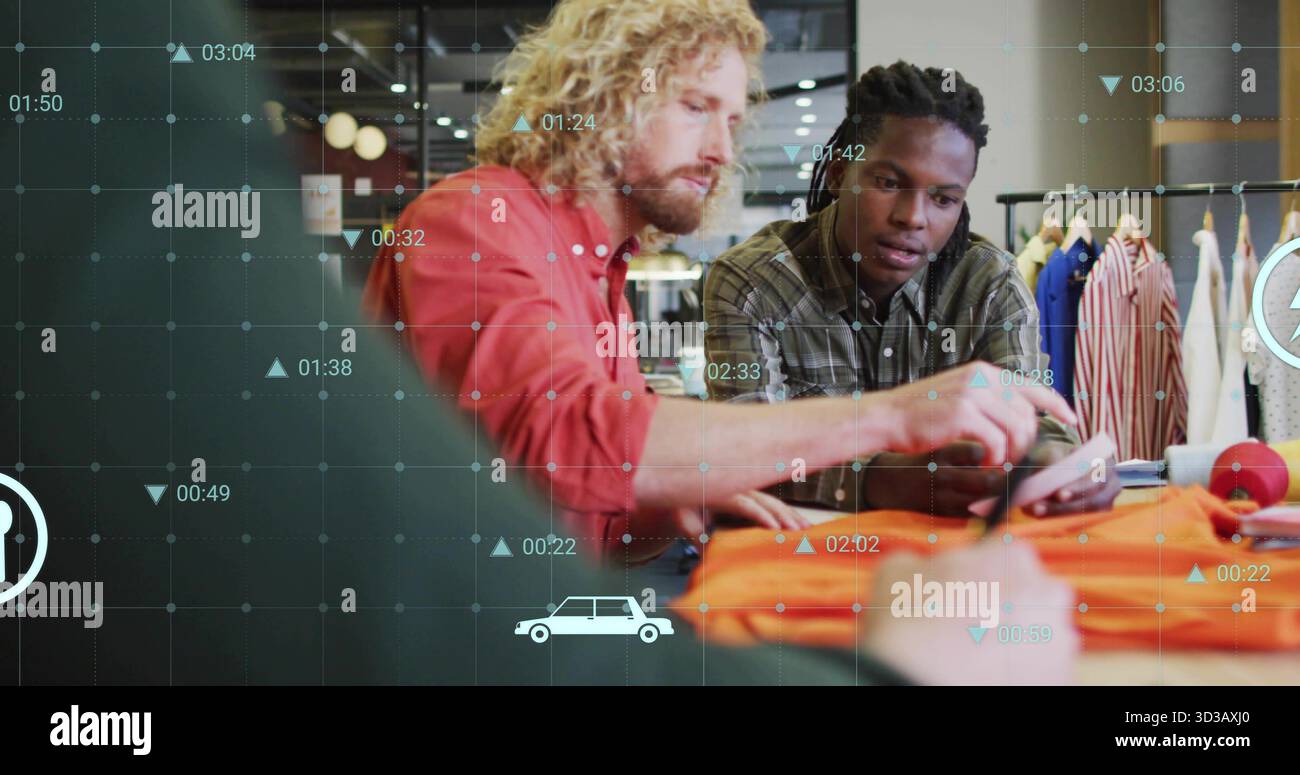 Two designers examining orange garment sample in retail showroom, with smartphone and data graphics Stock Photo