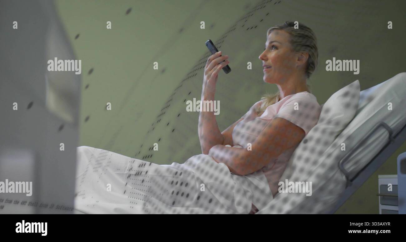Reclining patient holding smartphone to ear inside hospital scanner bore, showing white sheet Stock Photo