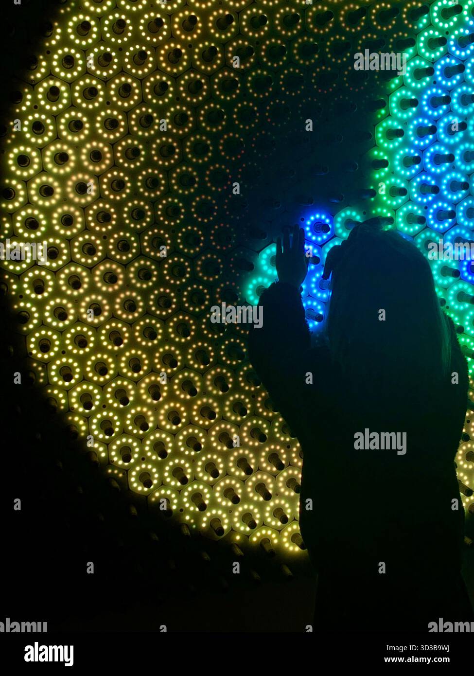 An LED light show with child orchestrating the patterns Stock Photo