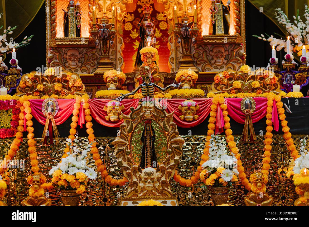 Detailed traditional Mexican Day of the Dead offering with marigold flowers, candles, and religious figures, celebrating life after death. Stock Photo