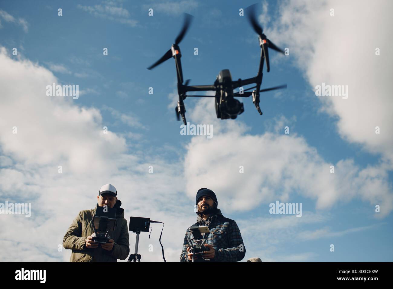 Man pilot controlling quadcopter drone with remote controller pad Stock Photo