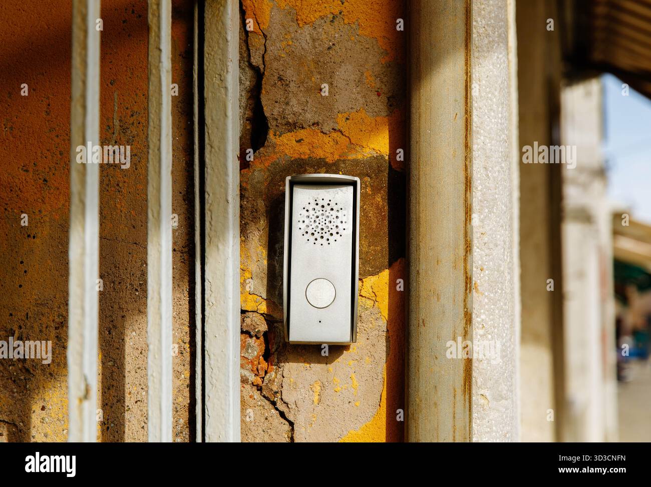 Weathered wall with modern intercom device on painted surface. Stock Photo