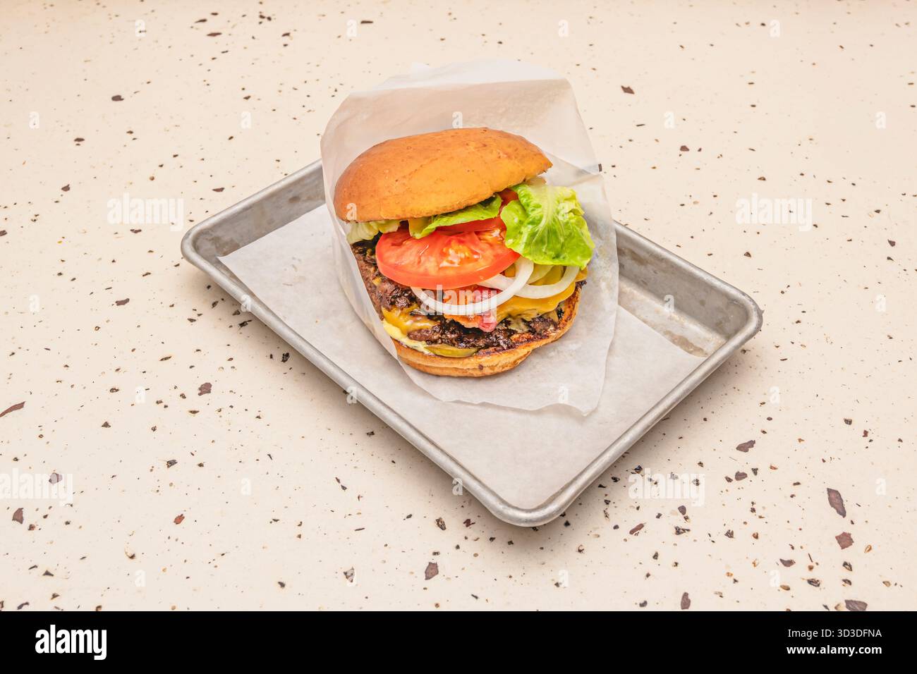 Beef burger with Provolone cheese, salami, and olives on Italian bread Stock Photo