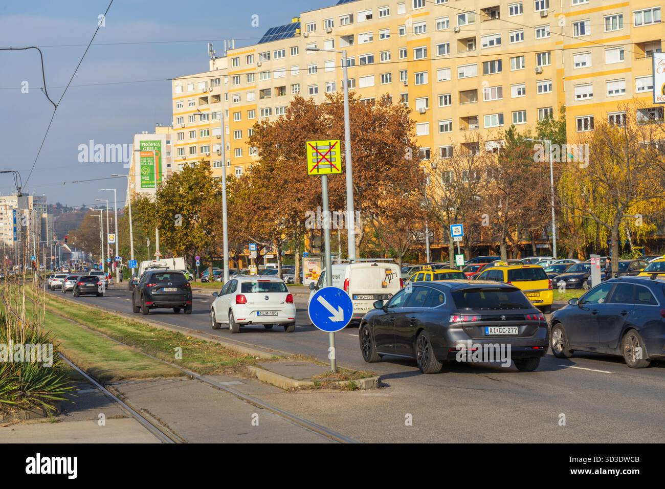 Busy Vorosvari Road in Obuda, Budapest, showing commuter traffic and large panel housing near Florian Square. Stock Photo