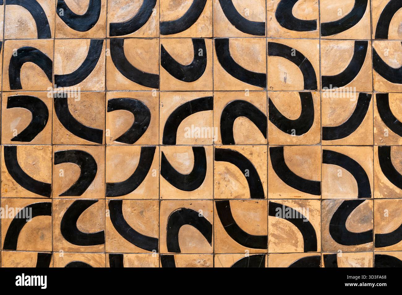 Square tiles forming a captivating pattern with black curves on a beige background, creating a visually appealing texture Stock Photo