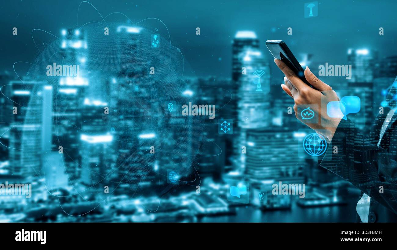 A businessman holds a smartphone against a stunning city skyline at night, emphasizing the integration of technology in urban life with a futuristic Stock Photo