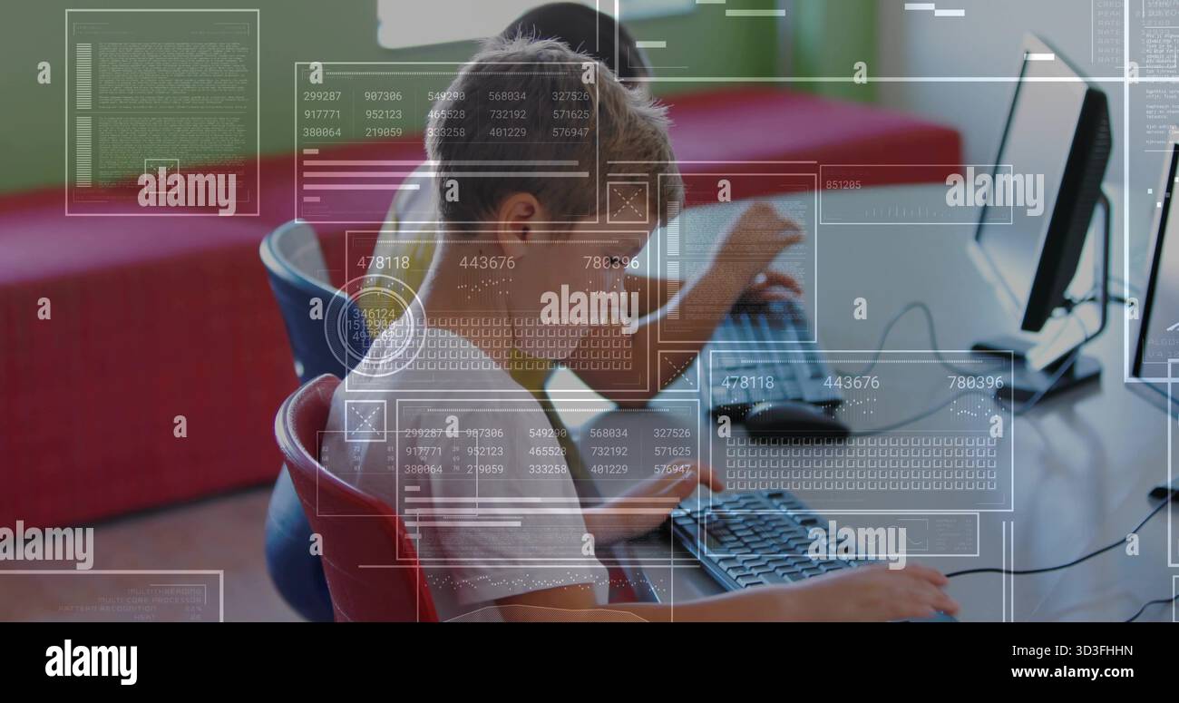 Working elementary students typing code on desktop monitors in coding lab, with digital overlays Stock Photo