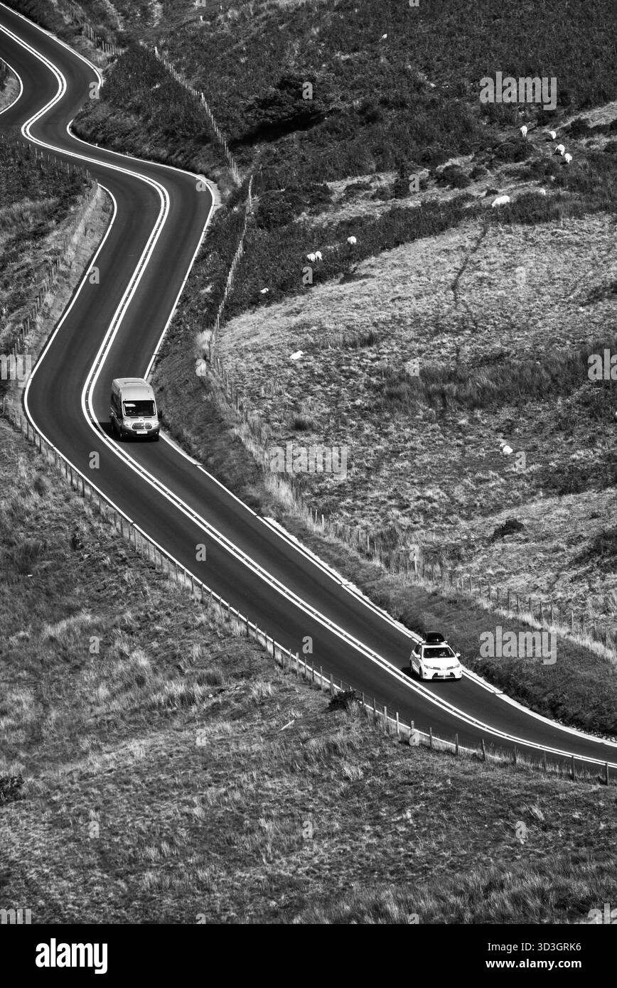 Black and white aerial view of a winding country road with vehicles ...