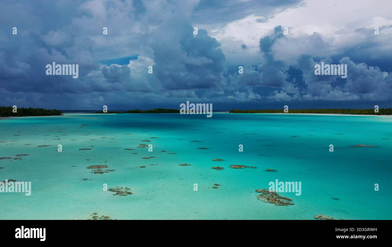 Aerial view of turquoise waters speckled with coral reefs under a ...