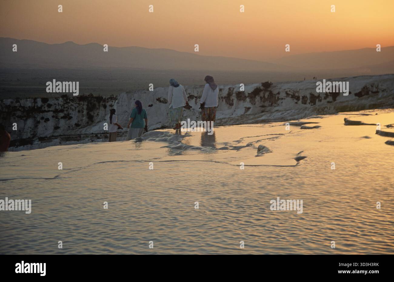 Group of local women at Pamukkale on the white travertine terraces  at sunset Stock Photo