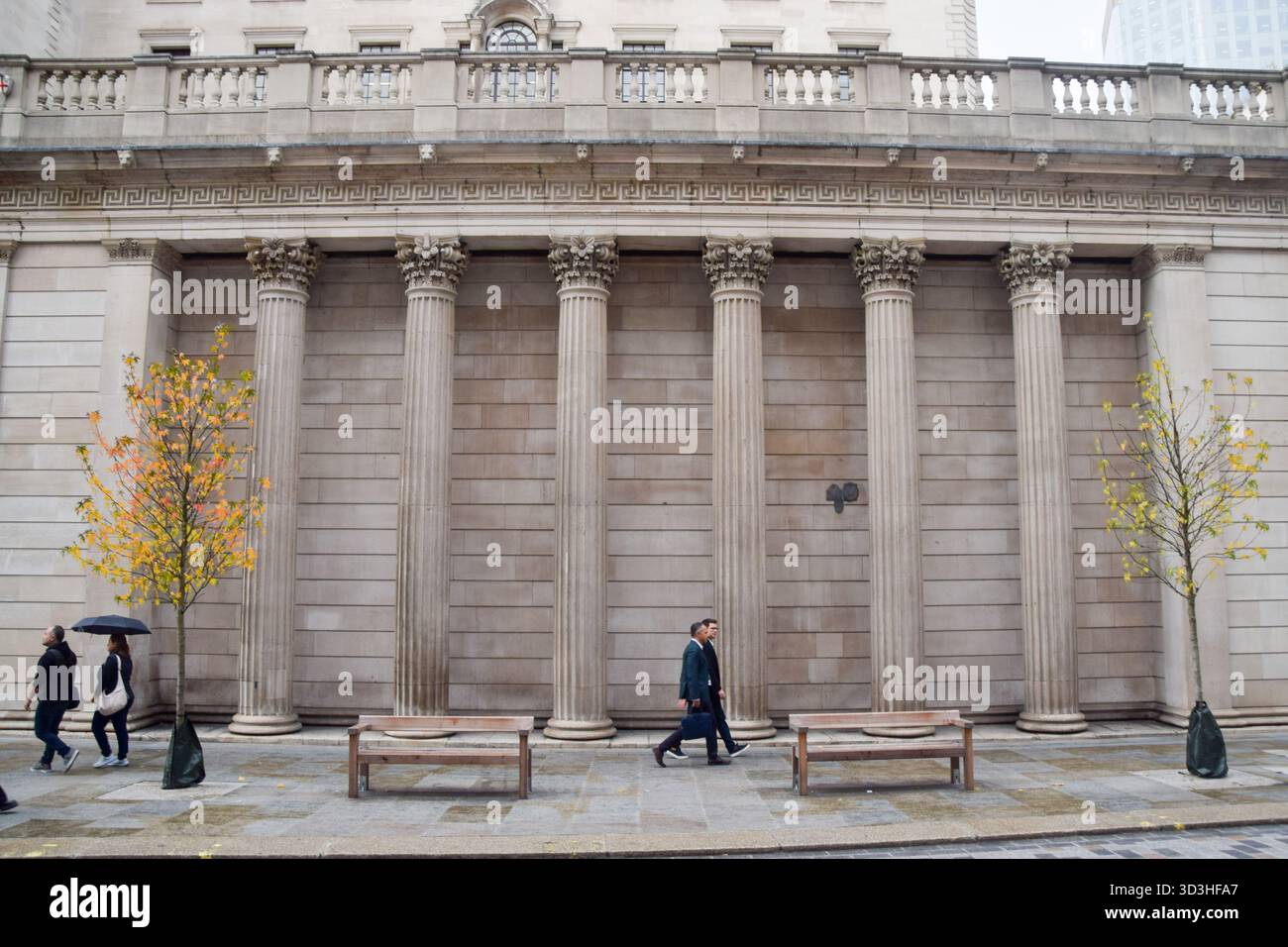 People walk past the Bank of England as it leaves interest rates unchanged. Stock Photo