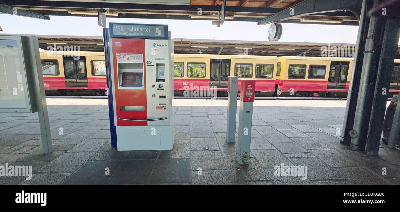 Berlin, Germany - June 13, 2025: Ticket machine at train station with train visible in background and urban environment. - Smartphone Captured Stock Image