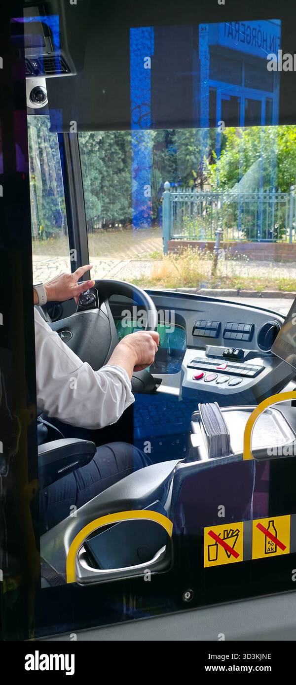 Berlin, Germany - August 07, 2025: Bus driver is operating the vehicle with dashboard controls in an urban environment. - Smartphone Captured Stock Image