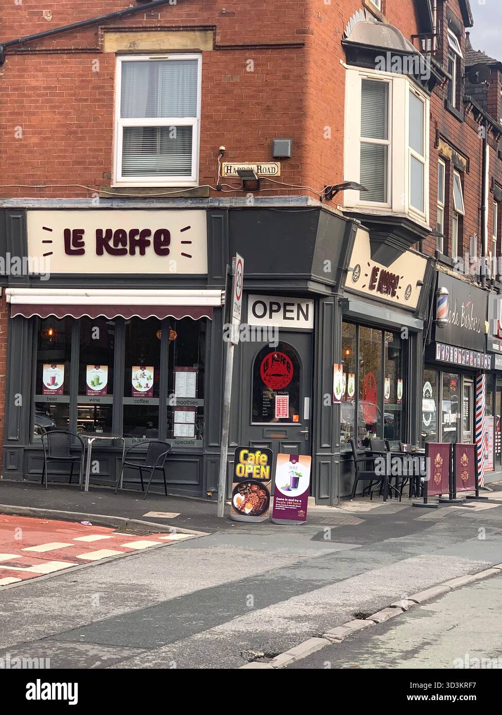 Leeds Bradford cafe LE Cafe open corner of a street sign signs outside pavement people eating food dinning in place hungry cooking open signs path - Smartphone Captured Stock Image