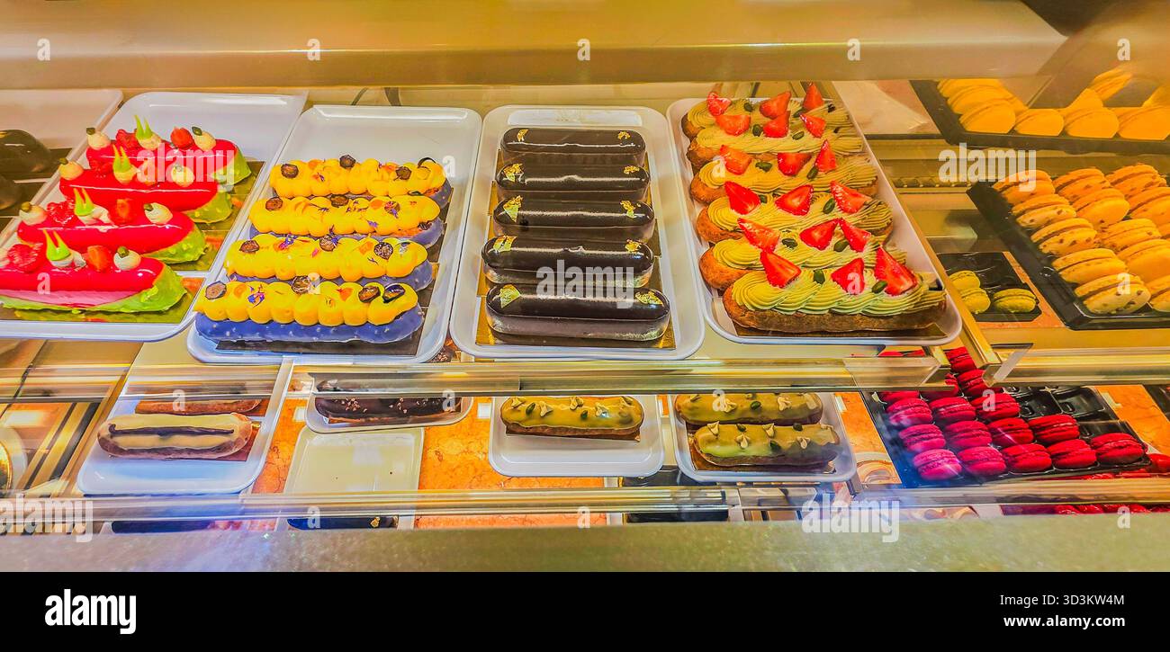 Colorful assortment of pastries displayed in a bakery showcase, featuring various textures and vibrant colors, enticing customers with sweet treats. - Smartphone Captured Stock Image