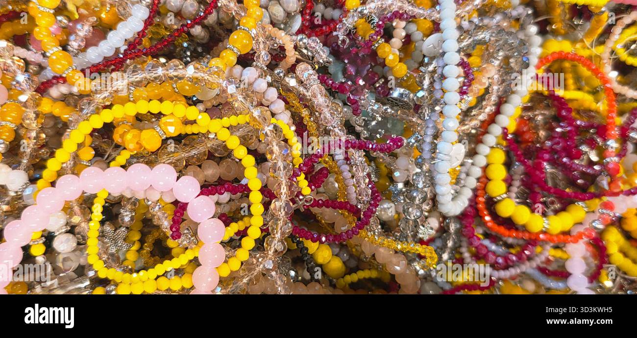 Colorful strands of beaded jewelry are artistically arranged, showcasing a variety of textures and hues in a vibrant display. - Smartphone Captured Stock Image