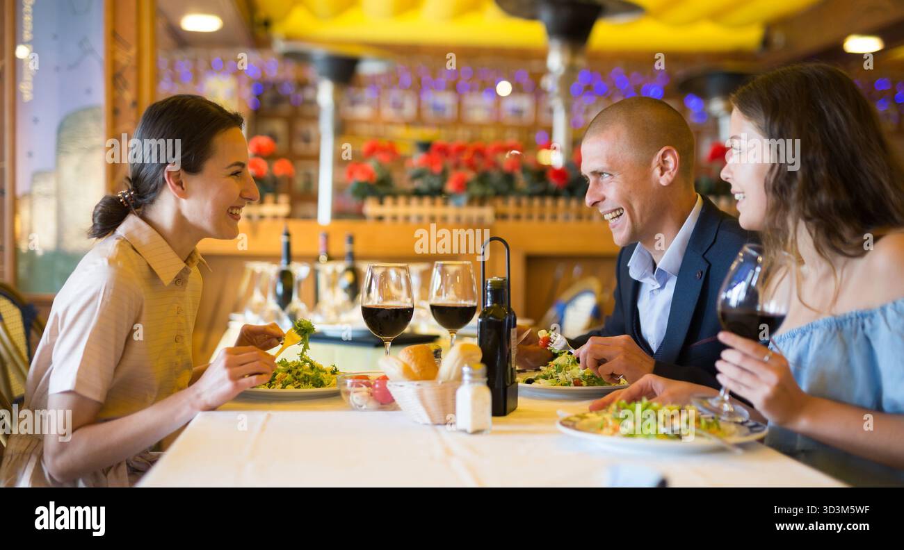 Two cheerful couples having dinner and nice talking Stock Photo