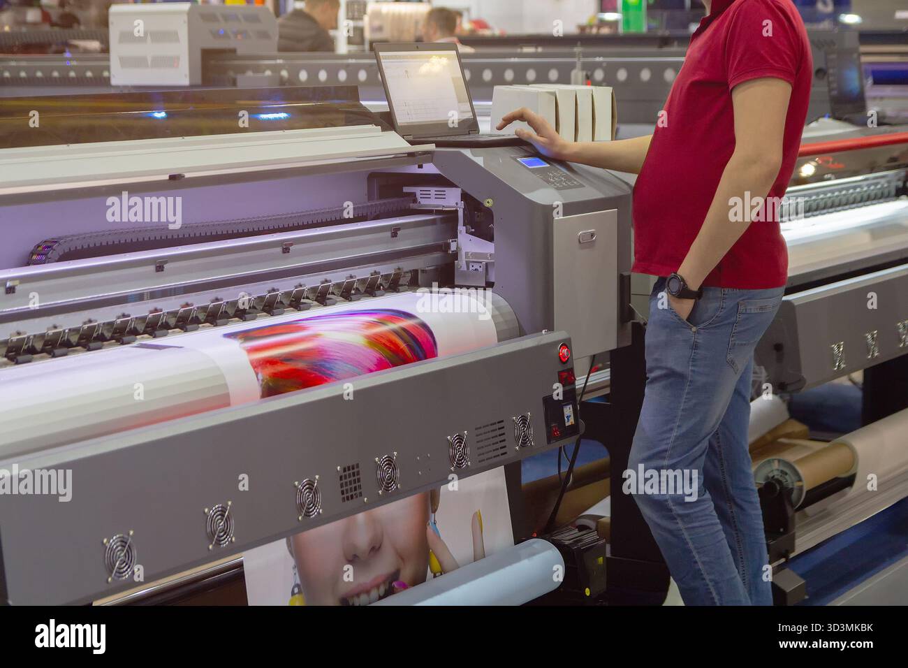 Printer operating printing machine in printing house. Industry Stock Photo