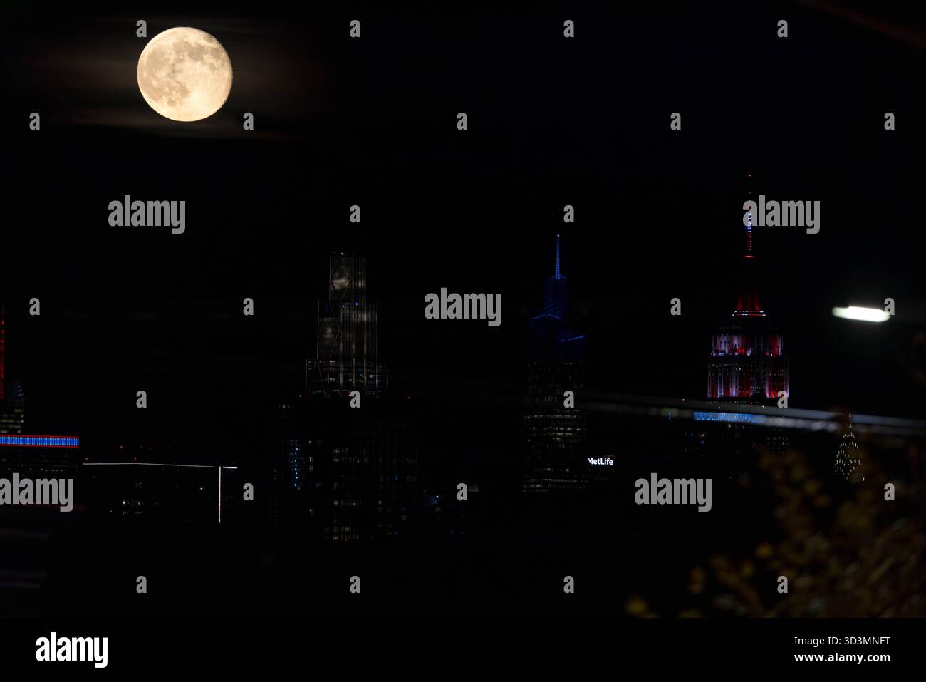 A full moon is seen next to the Empire State Building on Manhattan ...