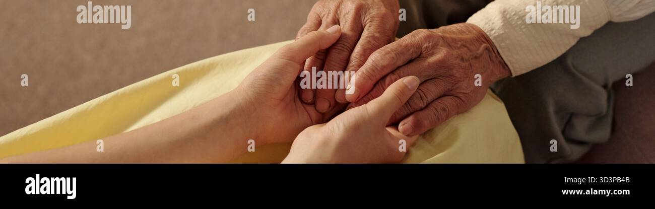 Senior Caucasian Woman Holding Hands with Young Adult Woman Offering Comfort Stock Photo