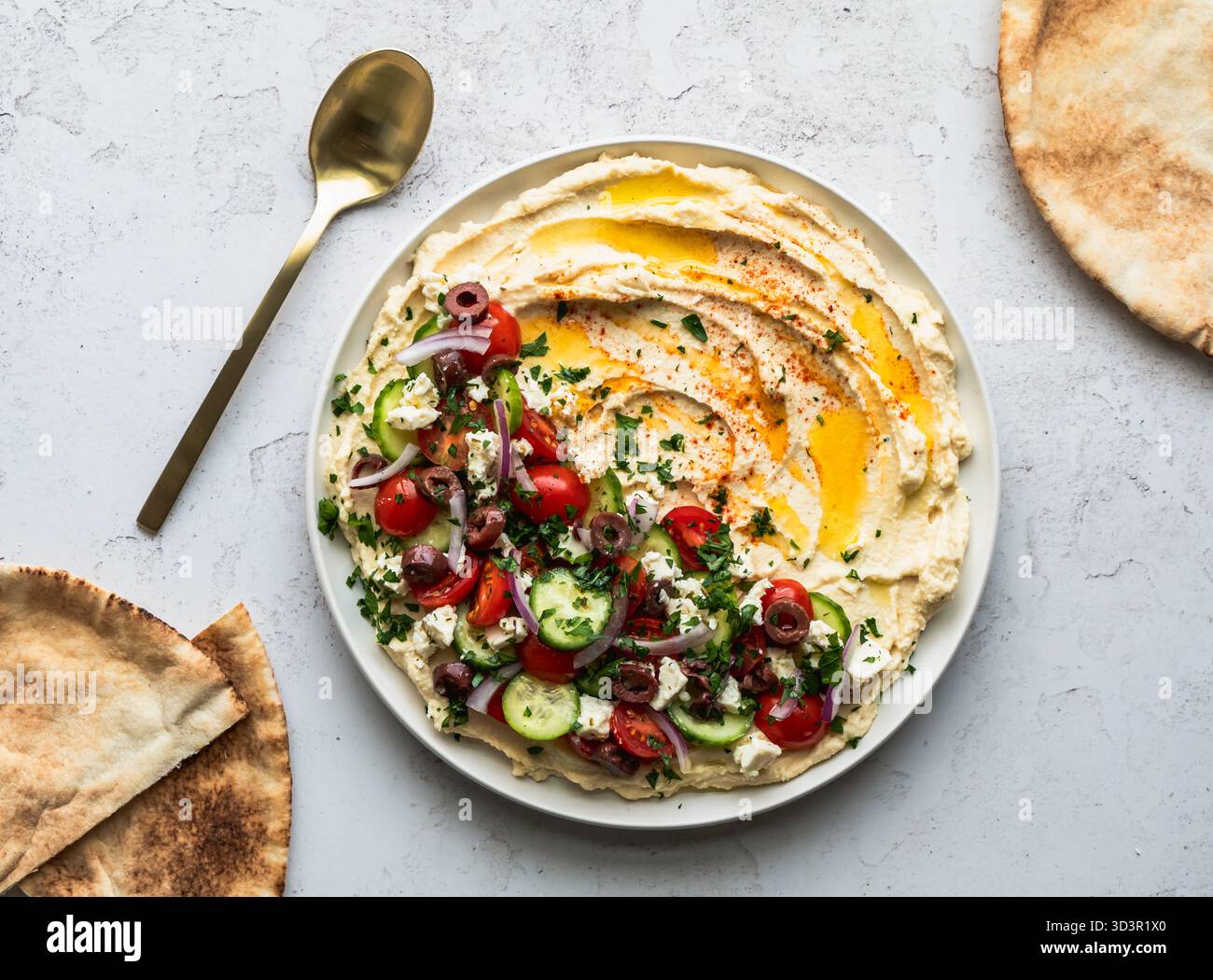 Top view hummus platter with medierranean ingredients and pitas. Stock Photo