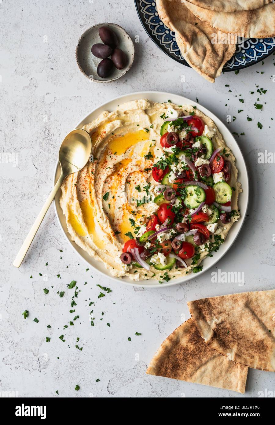 Top view hummus platter with medierranean ingredients and pitas. Stock Photo