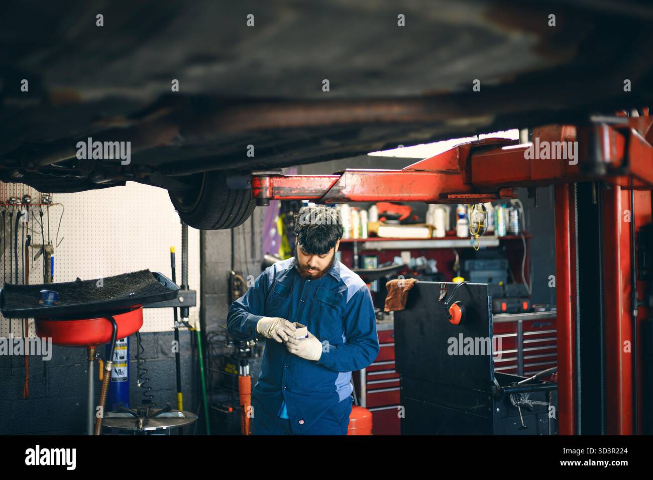 Workcomp Mechanic A mechanic is focused on his work under a vehicle Stock Photo - Alamy