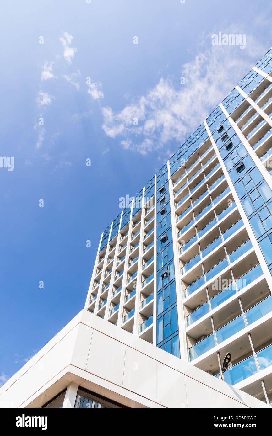 A modern high-rise building in the city with a sleek glass facade ...