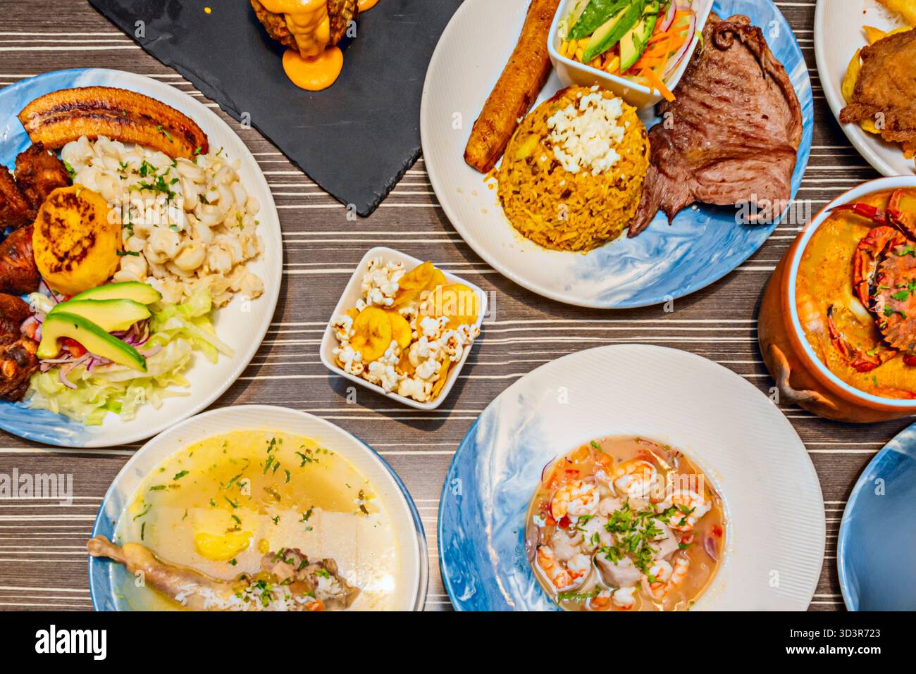 A bowl of Ecuadorian shrimp ceviche features seafood marinated in lime juice with tomato, cilantro, and red onion, accompanied by plantain chips and t Stock Photo