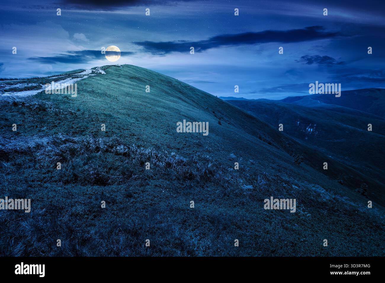 alpine meadows in mountains in summer at night. beautiful view of rolling hills with lush grass under dark sky in full moon light. travel destination. Stock Photo