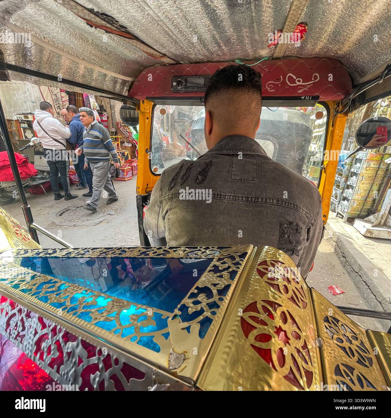 View from inside a TukTuk in Old Cairo, carrying a handmade traditional Ramadan lamp to celebrate the holy month, Cairo, Egypt - Smartphone Captured Stock Image