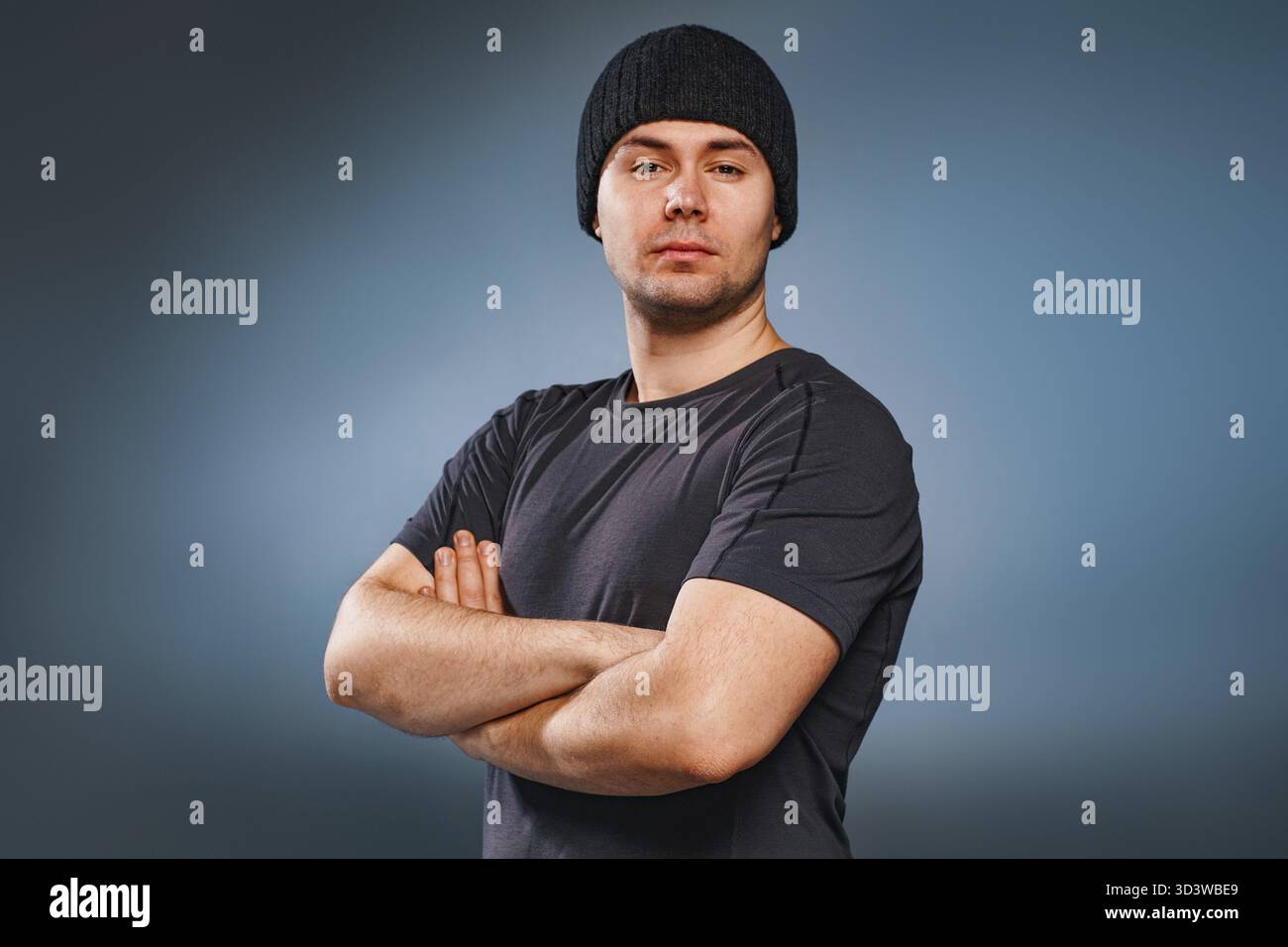 Young strong handsome man posing on gray background Stock Photo