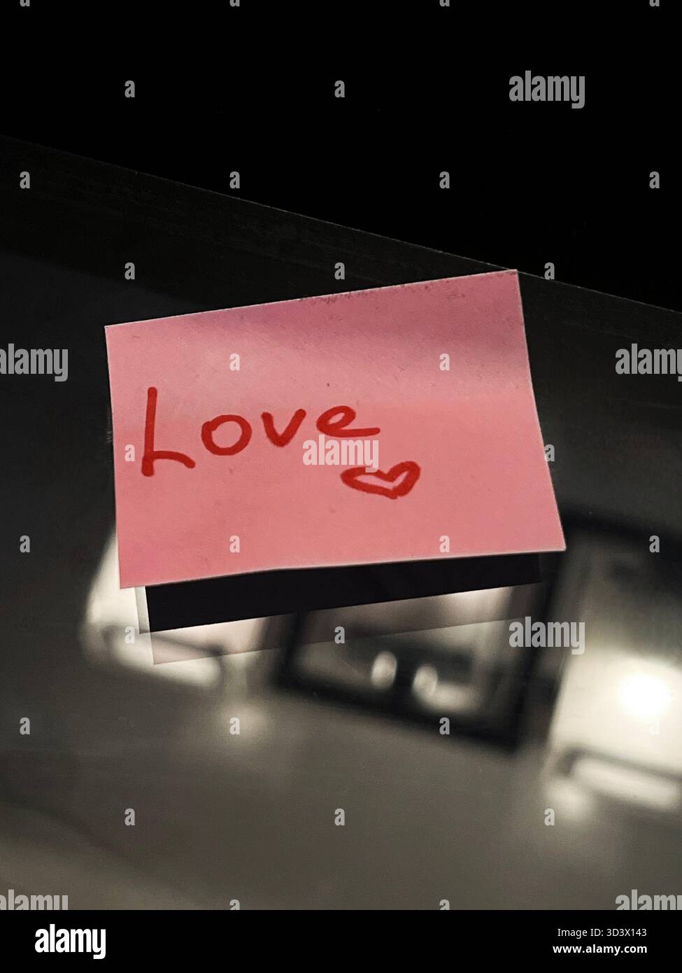The red word love and a heart on a pink sticker - Smartphone Captured Stock Image