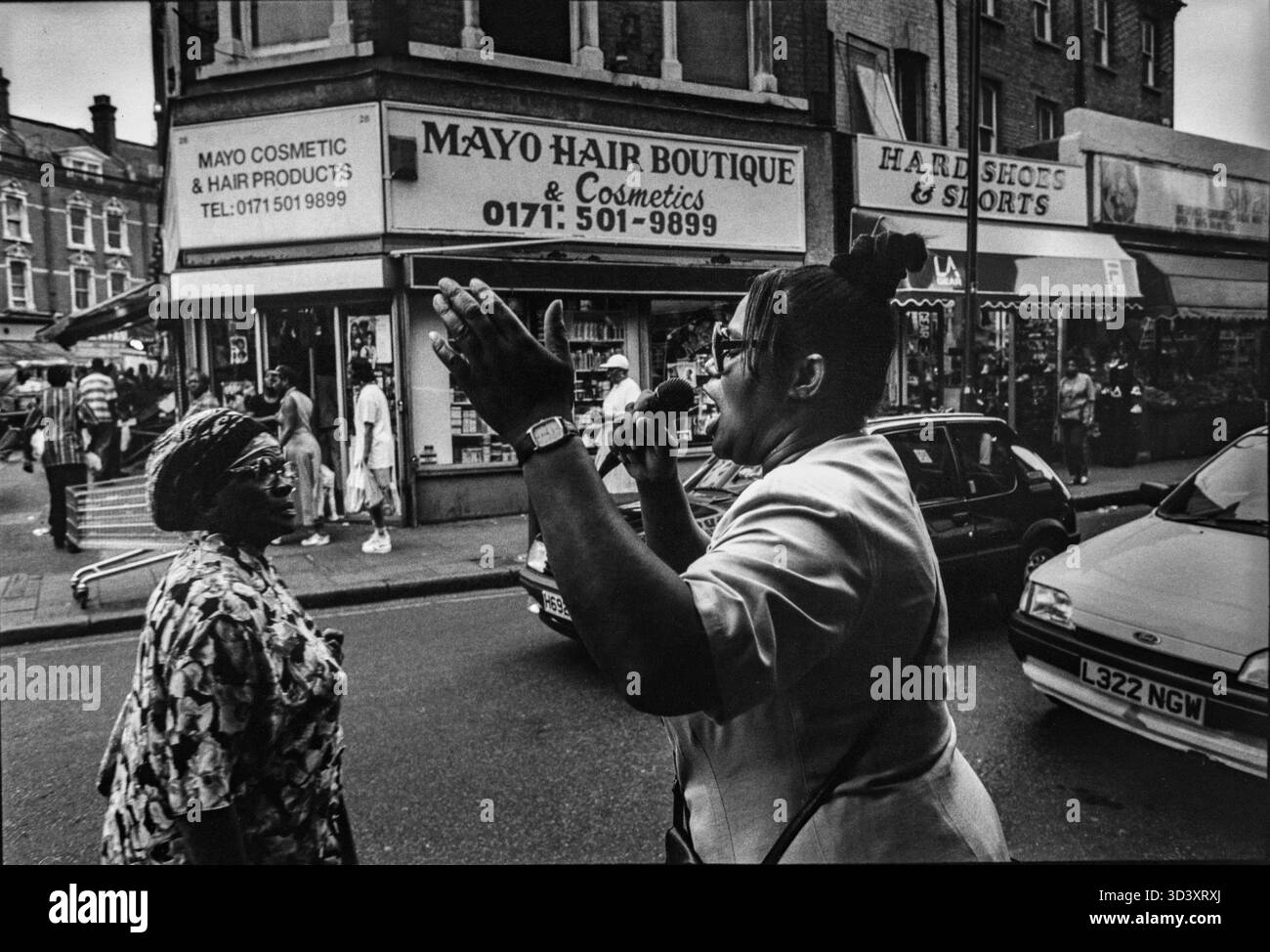 A gospel singer performs with passion on Atlantic Road in Brixton, London. Captured in 1996. Stock Photo