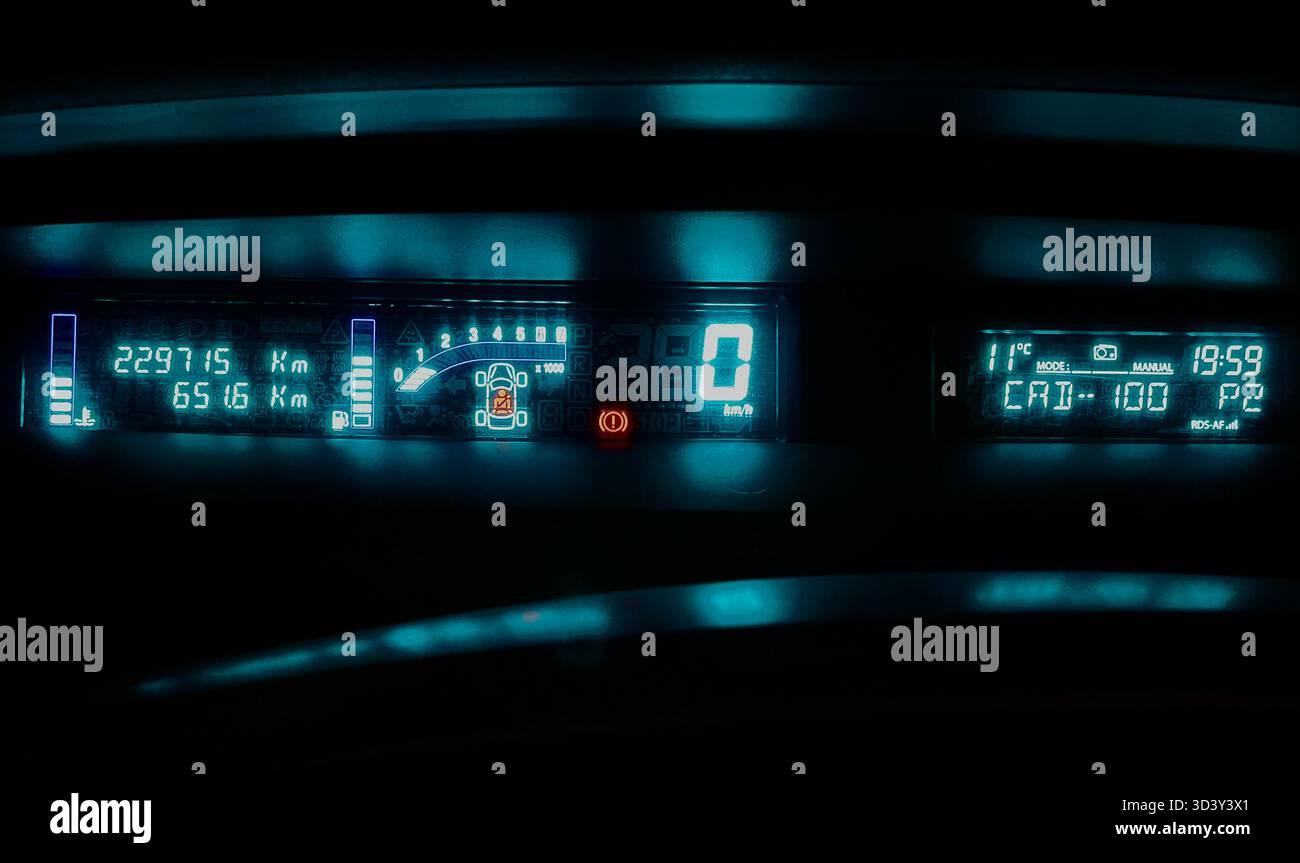 Glowing green LED digital dashboard display at night in a Spanish registered Renault Scenic Mark II French left hand drive car parked - Smartphone Captured Stock Image