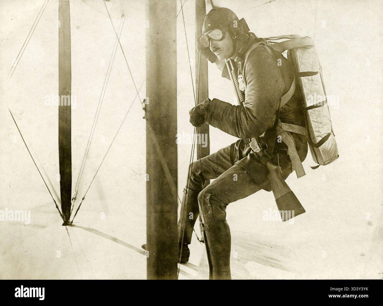 This 1923 photo captures a parachute jump from the wing of a biplane ...