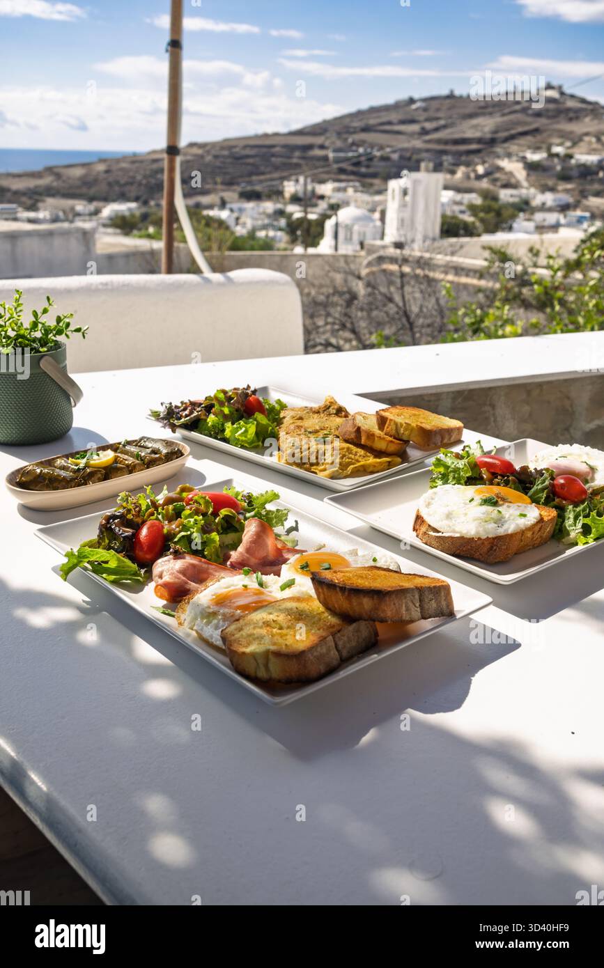 Breakfast and Brunch Spread Served Outdoors on a Terrace Overlooking a Mediterranean Village Stock Photo