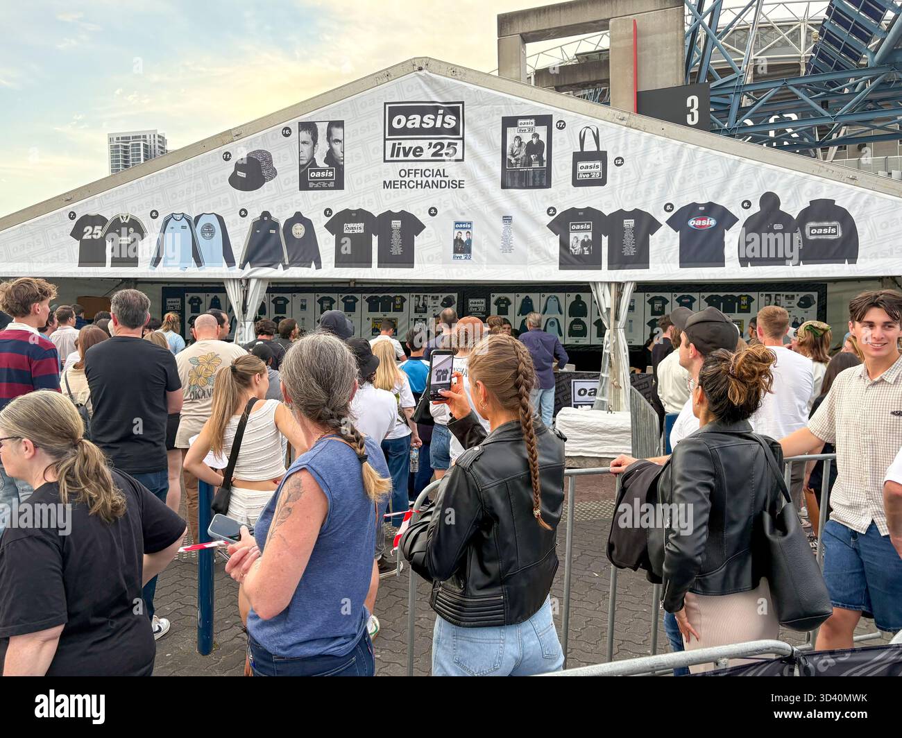 Oasis Live 25 tour, Sydney Accor Stadium, Oasis music fans queue to buy t shirts, bucket hats and mementos from Official merchandise shop, Australia - Smartphone Captured Stock Image