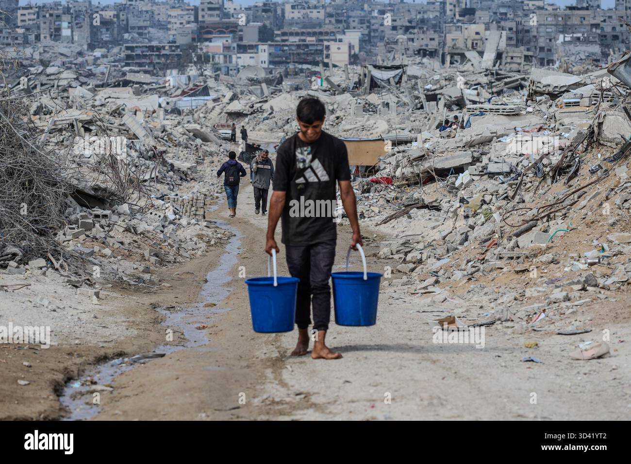 Northern Gaza, Palestine. 04th Nov, 2025. With water networks destroyed and infrastructure collapsed, children now bear the weight of daily survival. They carry heavy water containers across rubble-filled streets, a scene that reflects the harsh conditions and deep suffering civilians endure in the Strip, on November 4, 2025. Photo by Ramez Habboub/ABACAPRESS.COM Credit: Abaca Press/Alamy Live News Stock Photo
