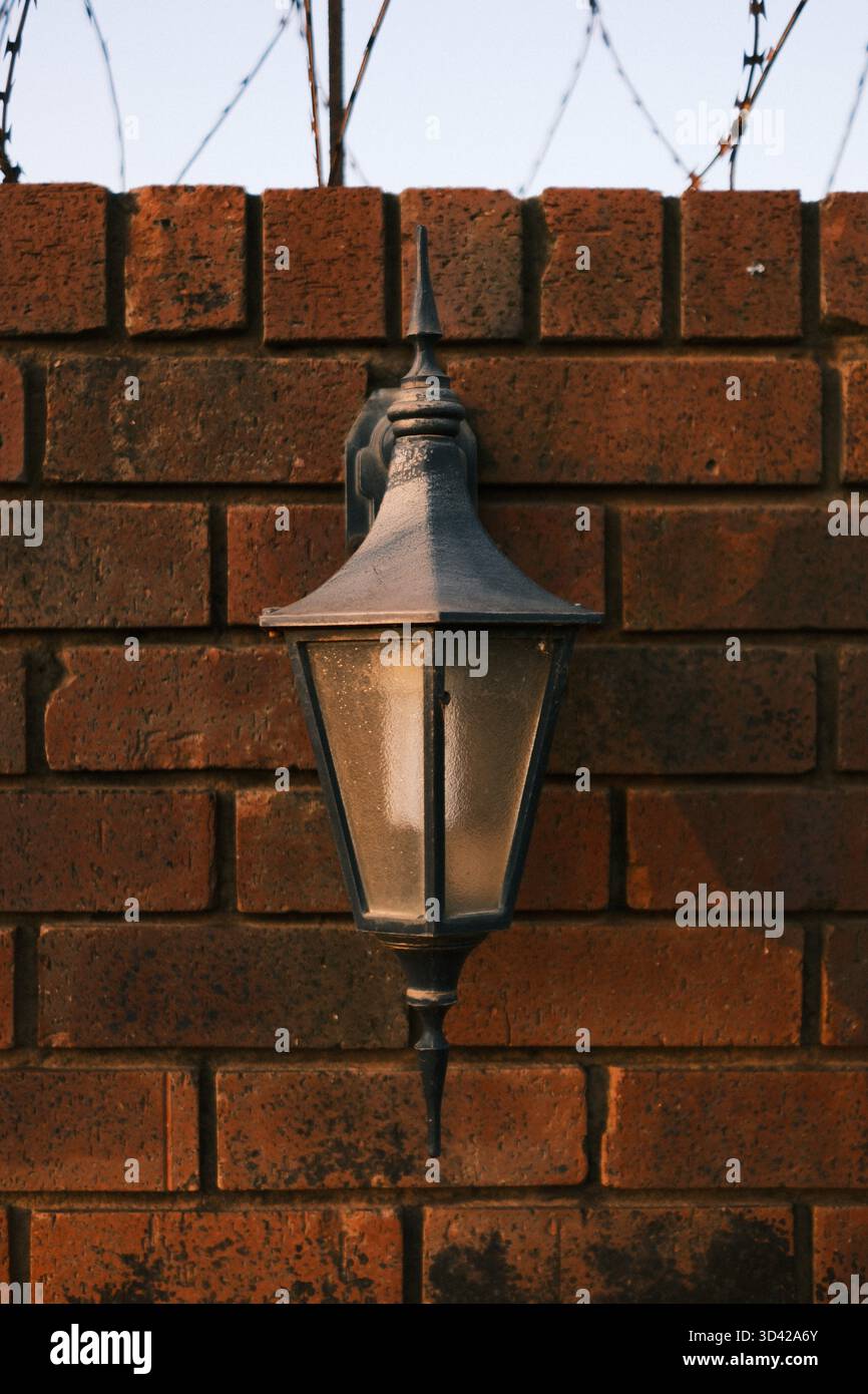Outdoor lantern mounted on red brick wall Stock Photo