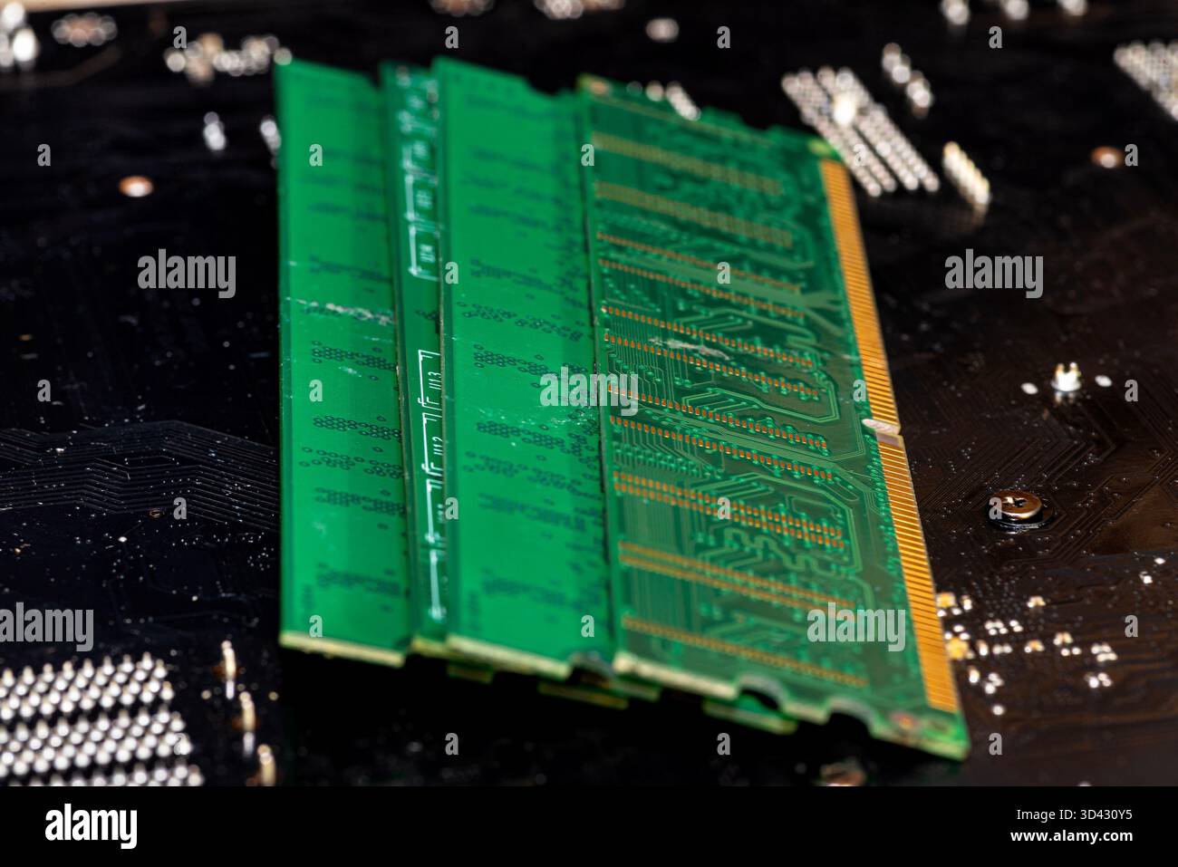 A stack of old SDRAM memory modules lying on a printed circuit board. Stock Photo