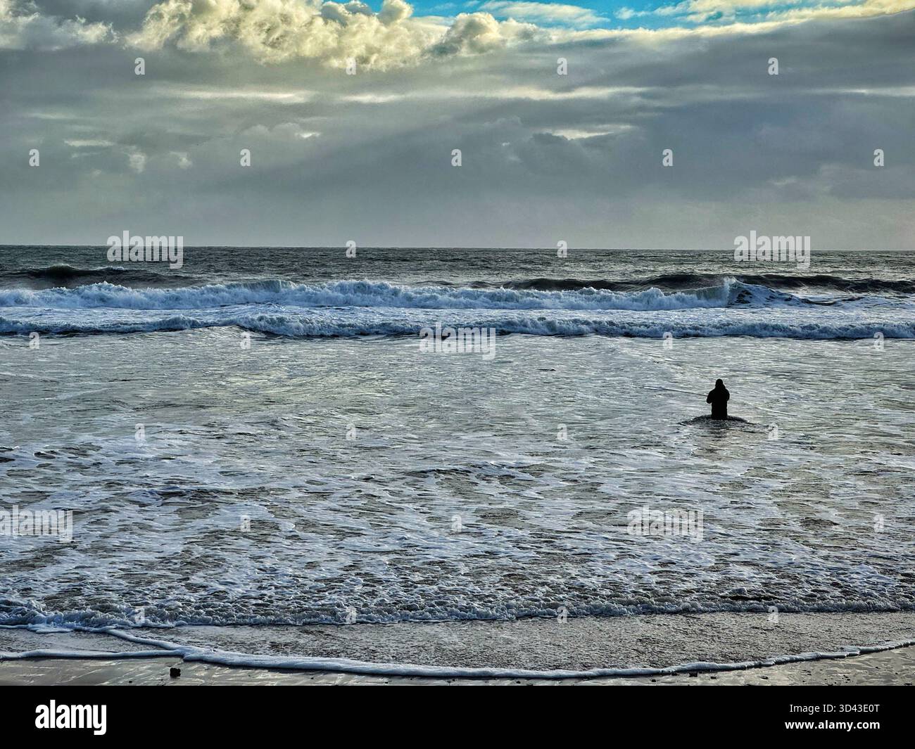 Sea angler fishing for bass at Caswell bay, Swansea, Gower, Wales - Smartphone Captured Stock Image
