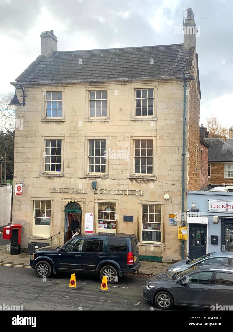Uppingham Rutland square cars shop shops car old stone history school hotel park parking kids people place village shopping post office shopping - Smartphone Captured Stock Image