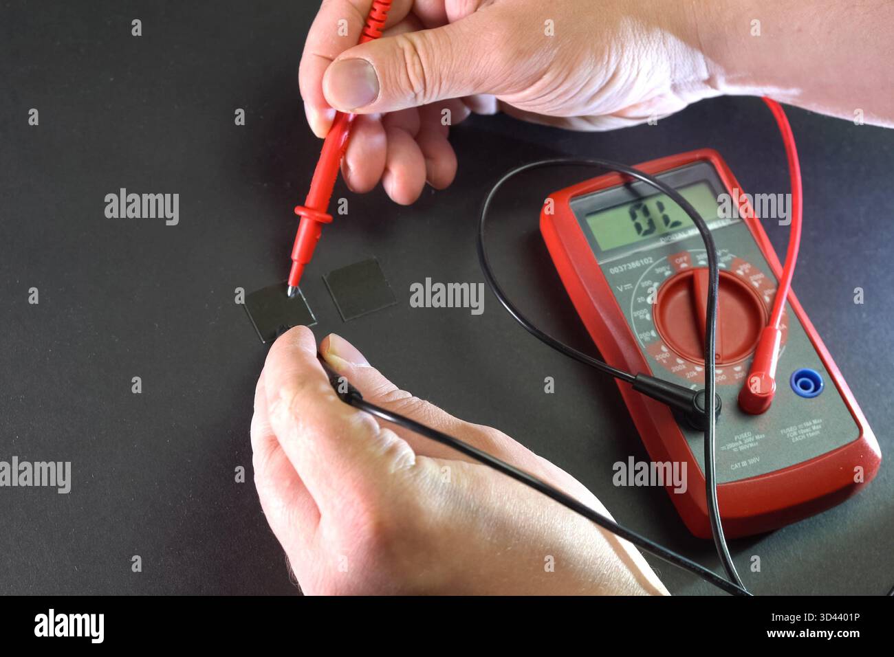 Measurement of product electrical parameters using a multimeter. Stock Photo